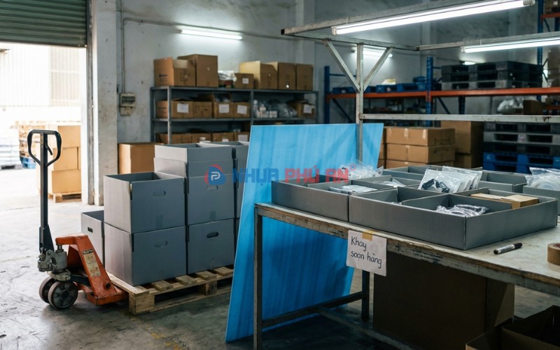 Thùng khay Danpla tái sử dụng có vách ngăn phân loại hàng trong khu vực soạn hàng tại kho xưởng Việt Nam